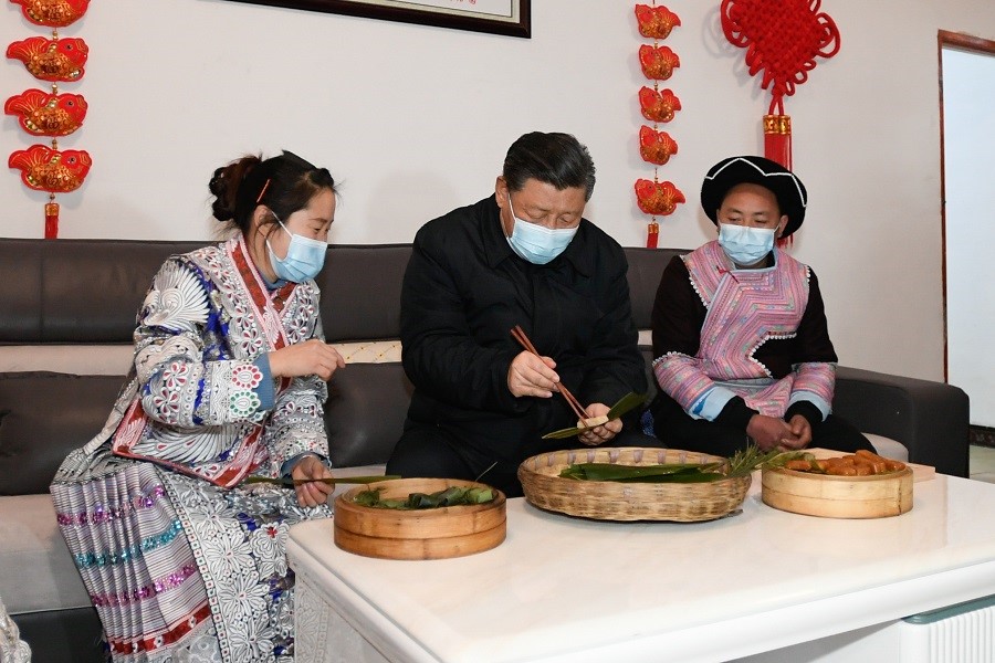 2021年2月3日下午，習近平在貴州畢節(jié)市黔西縣新仁苗族鄉(xiāng)化屋村苗族村民趙玉學家，同一家人邊聊家常邊制作當?shù)貍鹘y(tǒng)節(jié)日食品黃粑。新華社記者 李學仁 攝